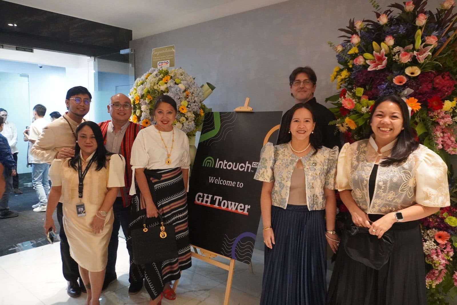 IntouchCX employees gathered beside the “Welcome to GH Tower” signage at the new campus opening